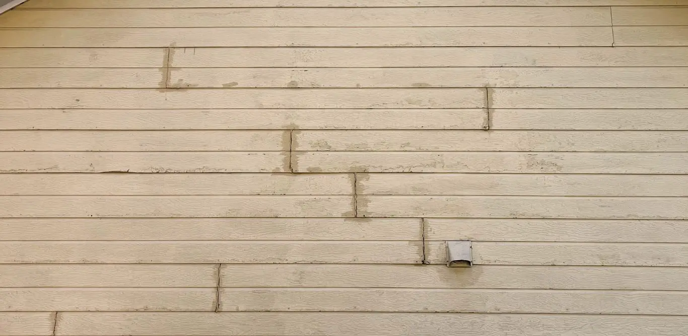A house in Helena AL with cracks in the Masonite siding.