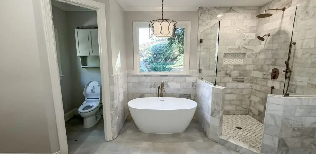 A functional bathroom in Mountain Brook, AL, with a private lavatory, free-standing tub, and a walk-in shower.