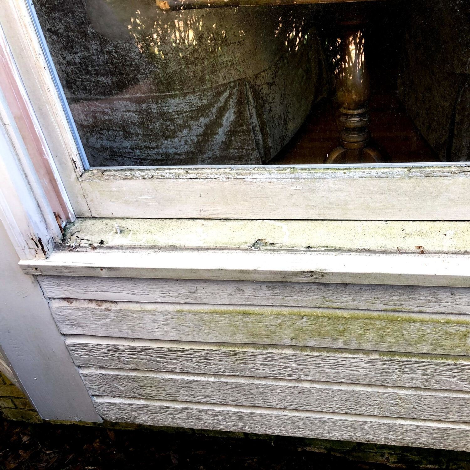 A water damaged window with cracks in the sill, allowing water behind the siding.