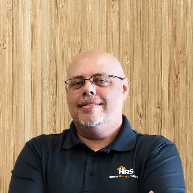 a man wearing glasses and smiling at the camera
