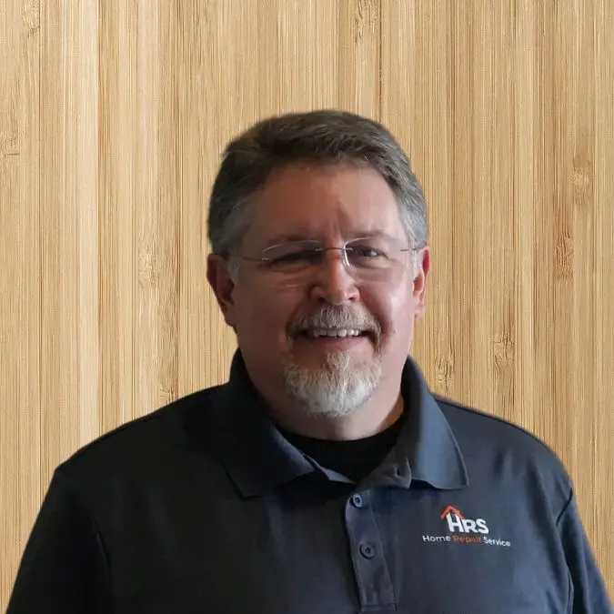 a man wearing glasses and smiling at the camera