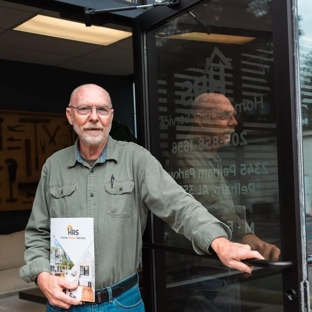 The business owner standing in front of the Home Repair Service office.