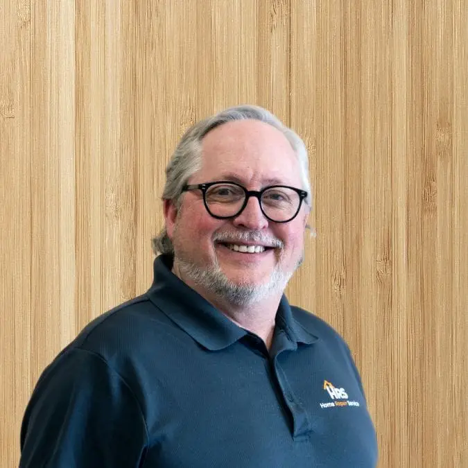 a man wearing glasses and smiling at the camera