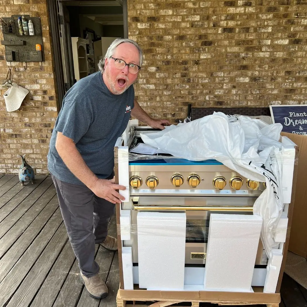 A contractor unpacking a high-end oven during a kitchen remodeling project in Pelham, AL