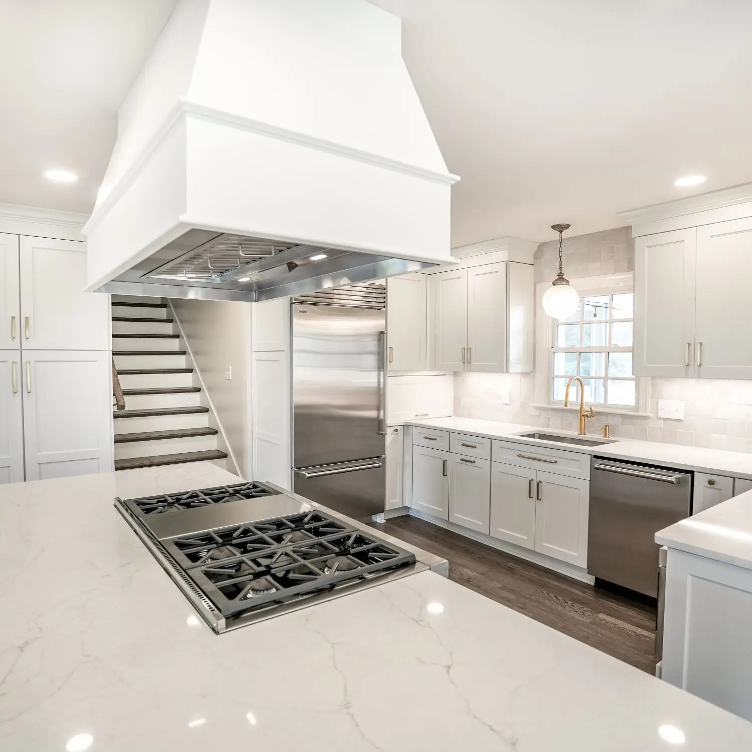 A modern kitchen with an open layout, featuring a large island, Sub-Zero refrigerator, and custom finishes for a seamless blend of style and efficiency.