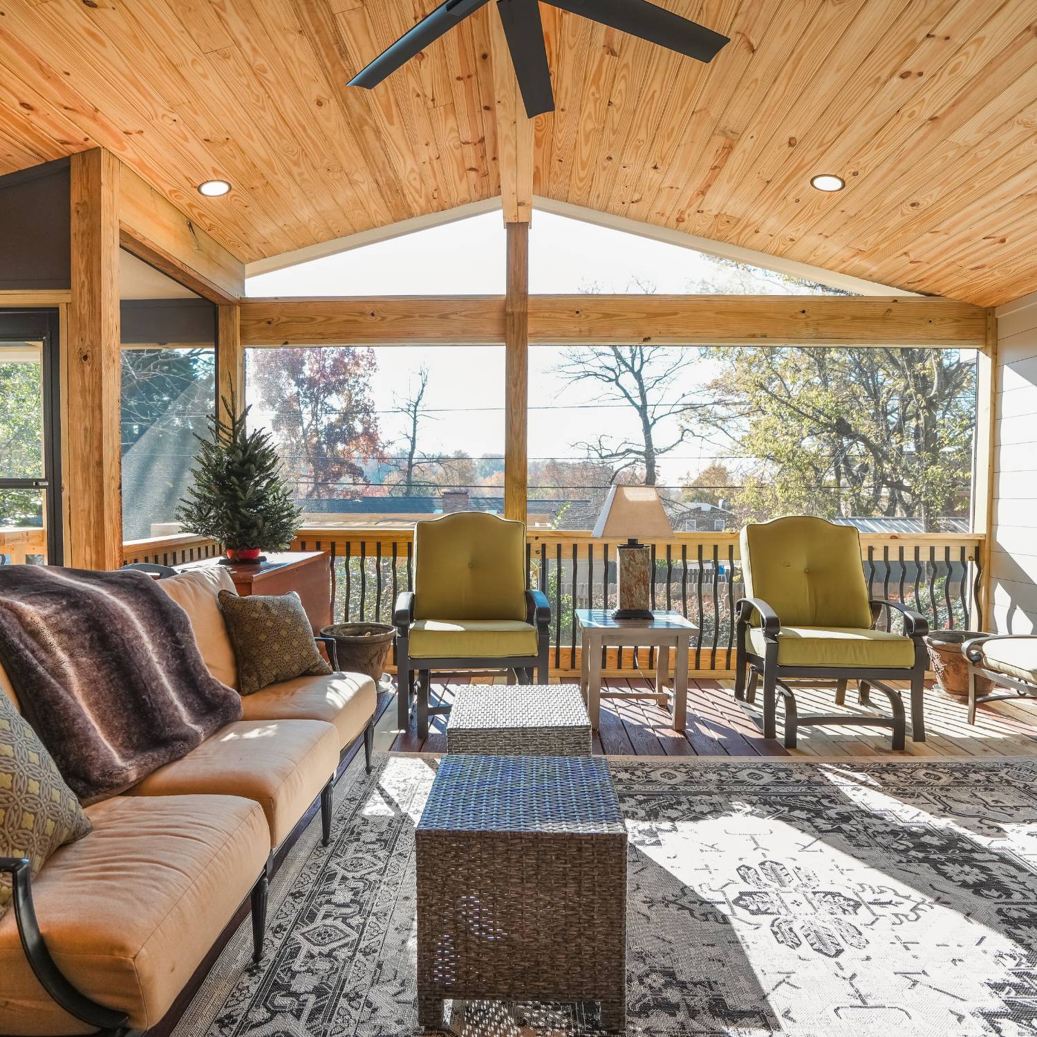 A deck builder in Vestavia Hills, AL, constructing a screened-in porch with exposed wood beams for a cozy outdoor space.