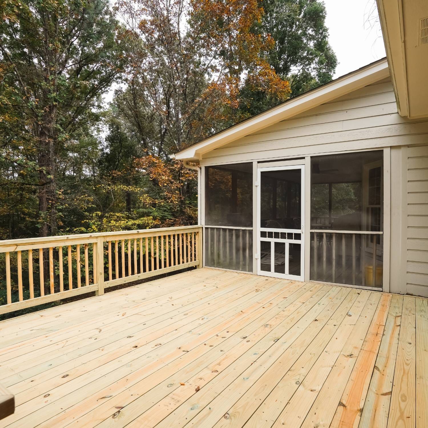 A deck replacement in Vestavia Hills, AL, featuring a brand-new wooden deck with strong railings and a smooth finish.