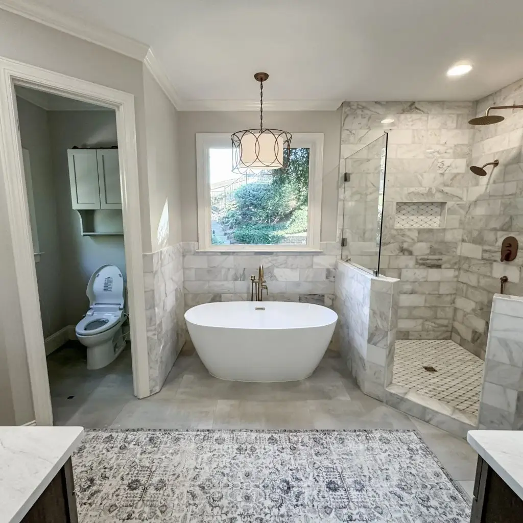 A high-end master bathroom remodel with a freestanding tub, marble tile, and a walk-in shower, typically costing $40,000–$50,000.