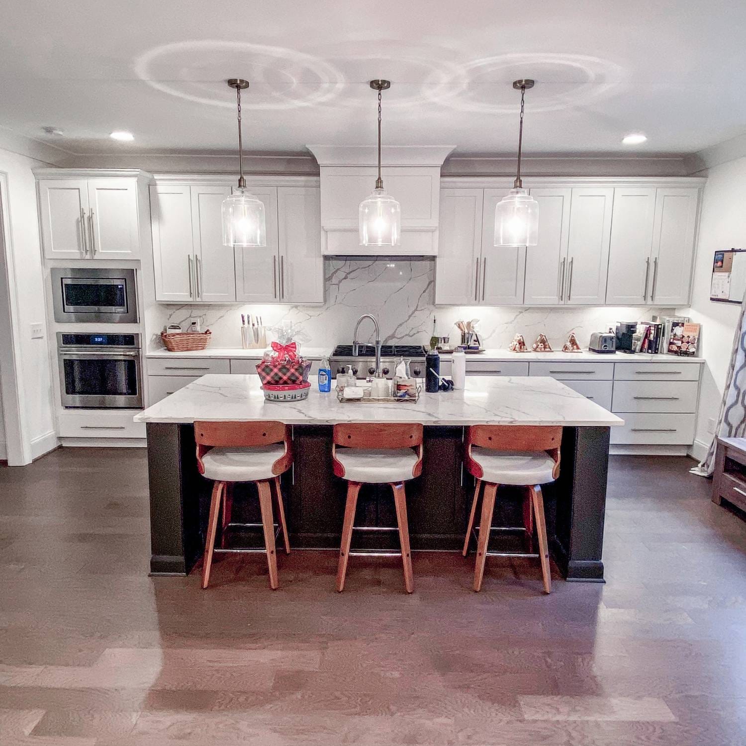 A kitchen remodeler in Vestavia Hills, AL, designed this modern kitchen with custom cabinetry, quartz countertops, and stylish pendant lighting for a warm and functional space.