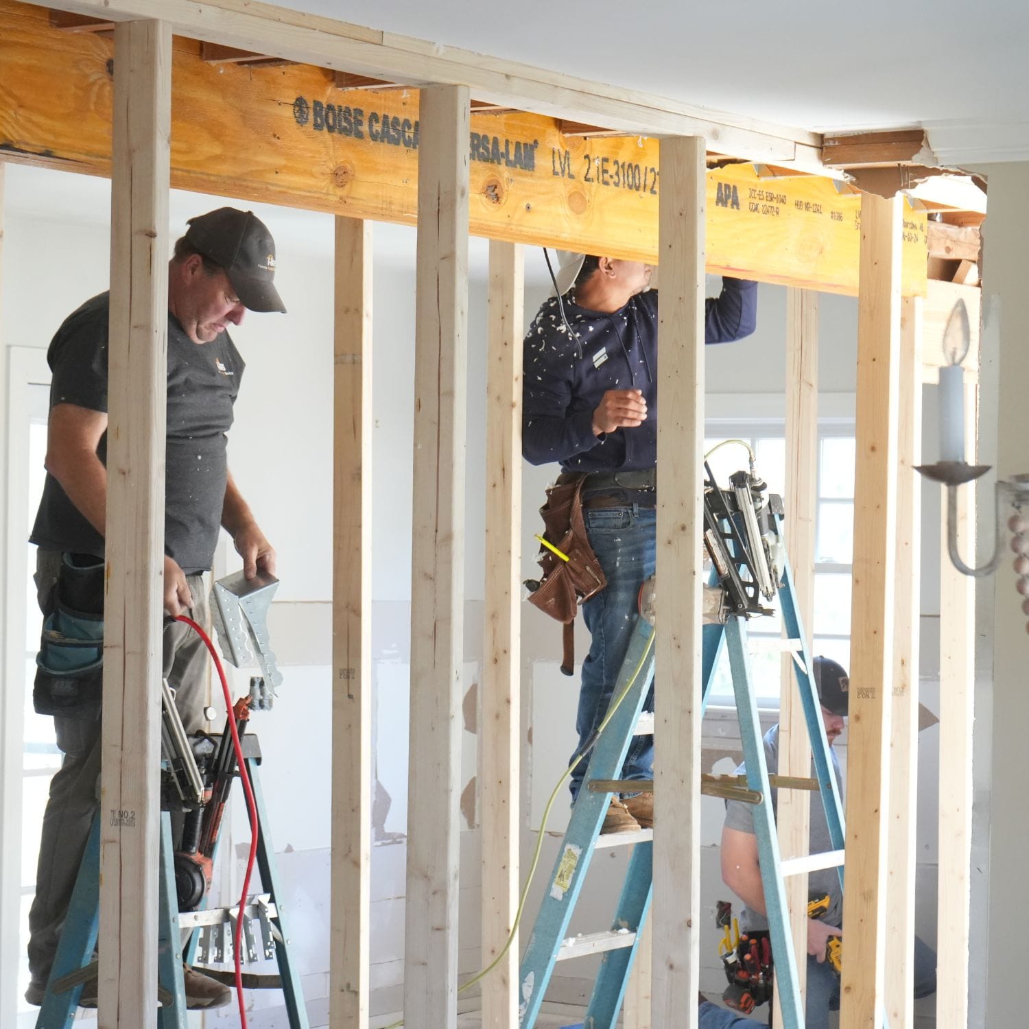 Contractors installing structural beams and framing new walls as part of a home remodeling project in Alabaster, AL.
