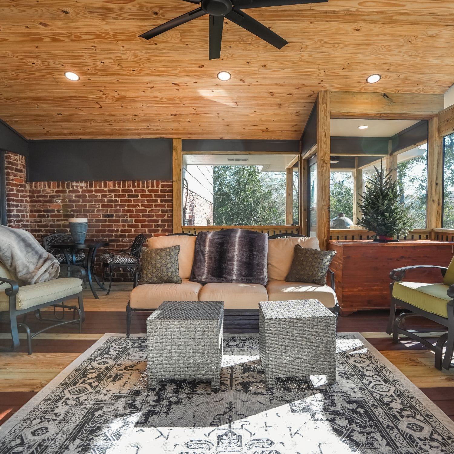 Our recent deck building project in Alabaster, AL was screened-in with a wood ceiling and brick accent wall, creating a cozy outdoor living space.