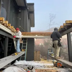 The deck demolition process reveals areas of siding damage that needed repair before the new deck installation.