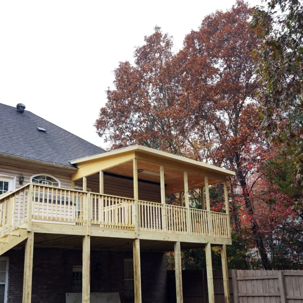 High-elevation porch showing how to add a roof to an existing deck with proper framing and footings.