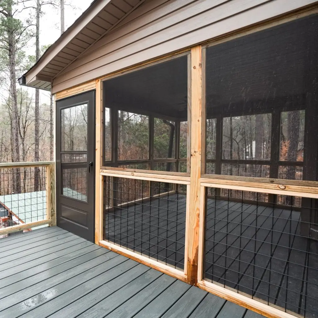 Screened-in covered porch with wire railing and wood framing built on an existing deck in Pelham, AL.