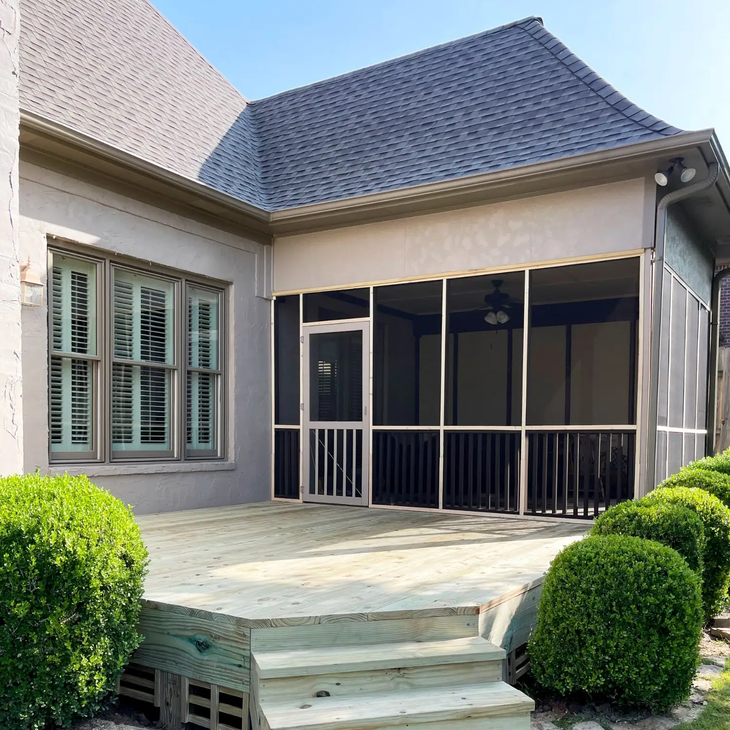 Screened-in porch with angled pressure-treated deck and stairs, built to match home exterior in Pelham, Alabama.