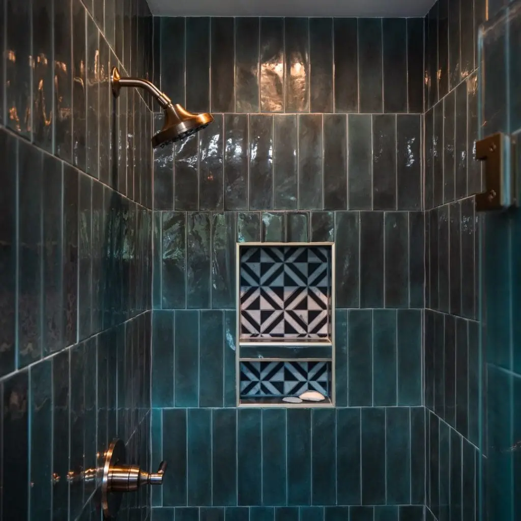Walk-in shower with glossy vertical green tiles, a built-in niche featuring matching patterned mosaic tile, and brushed gold fixtures.