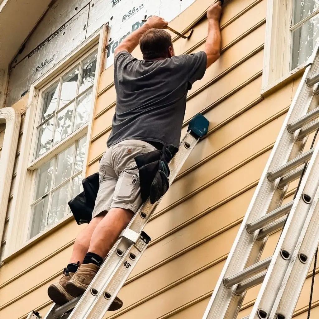 Experienced siding contractor in Mountain Brook replacing old siding with new material on a residential home.